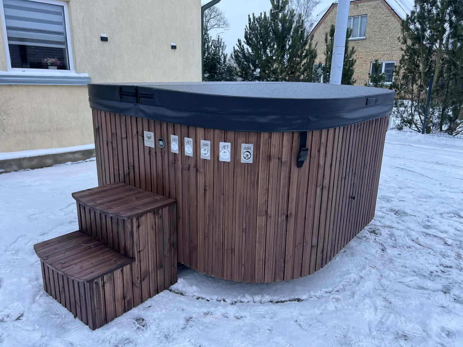BubbleSpa wooden hot tub with insulated cover set up outdoors in winter